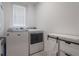 Well-organized laundry room with white machines and modern storage, and bright natural light at 29810 Anahid Dr, Leesburg, FL 34748