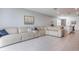 Open-concept living room with a beige leather couch and tile flooring at 29810 Anahid Dr, Leesburg, FL 34748