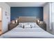 Relaxing main bedroom setup with a comfortable bed, side tables, and tasteful decorations against a blue wall at 29810 Anahid Dr, Leesburg, FL 34748