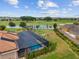 Backyard aerial view with screened pool and golf course and water view at 3097 Bureau Path, The Villages, FL 32163