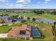 Aerial view of a home with a screened pool, lush backyard, and golf course frontage at 3097 Bureau Path, The Villages, FL 32163