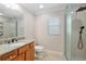 Bathroom with granite countertops, a glass-enclosed shower and a large mirror for a modern feel at 3097 Bureau Path, The Villages, FL 32163