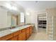 Bathroom with spacious vanity, granite countertop, and walk-in closet at 3097 Bureau Path, The Villages, FL 32163