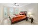 Cozy bedroom with natural light, shuttered windows, fan, and decorative pillows for comfortable living at 3097 Bureau Path, The Villages, FL 32163