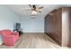Spacious bedroom with Murphy bed, soft chair, and ceiling fan at 3097 Bureau Path, The Villages, FL 32163