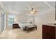 Bright bedroom with fan, ensuite bath, and sliding doors to outdoor patio at 3097 Bureau Path, The Villages, FL 32163