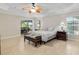 Bright bedroom with fan, ensuite bath, and sliding doors to outdoor patio at 3097 Bureau Path, The Villages, FL 32163