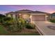 Inviting front exterior with manicured landscaping, decorative driveway, and two-car garage at 3097 Bureau Path, The Villages, FL 32163