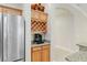 Butler's pantry with stainless steel refrigerator, beverage center, granite counters, and wooden cabinets at 3097 Bureau Path, The Villages, FL 32163