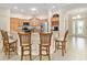 Kitchen with granite countertops, stainless steel appliances, bar seating, and a convenient beverage station at 3097 Bureau Path, The Villages, FL 32163