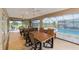 Outdoor dining area on the lanai with views of the pool, lush greenery, and waterfall feature at 3097 Bureau Path, The Villages, FL 32163
