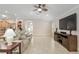 Bright living room featuring tile floors, a ceiling fan, comfortable seating, and a media center at 3097 Bureau Path, The Villages, FL 32163