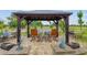 Beautiful outdoor living space with a pergola, water view, and cozy rocking chairs at 3097 Bureau Path, The Villages, FL 32163