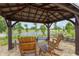 Relaxing outdoor area with pergola, wooden chairs and a picturesque lake view at 3097 Bureau Path, The Villages, FL 32163