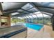 Indoor pool featuring a hot tub, bar, seating area, and a scenic mural, creating a luxurious and relaxing space at 3097 Bureau Path, The Villages, FL 32163