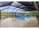 Screened-in pool area with a waterfall feature, seating, and landscaped yard at 3097 Bureau Path, The Villages, FL 32163