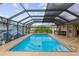 Screened in pool with a jacuzzi, waterfall feature, and ample space for relaxation at 3097 Bureau Path, The Villages, FL 32163