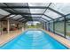 Indoor pool featuring an outdoor seating area, scenic mural, and providing the perfect relaxing space at 3097 Bureau Path, The Villages, FL 32163