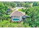 Overhead aerial view of backyard featuring a sparkling pool, screened enclosure, and lush landscaping at 34231 Shadewood Cir, Leesburg, FL 34788