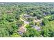 An aerial view of a residential neighborhood featuring houses with lush green trees and well-maintained lawns at 34231 Shadewood Cir, Leesburg, FL 34788