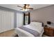 Well lit bedroom with a ceiling fan, two closets, a nightstand, and a gray color scheme at 34231 Shadewood Cir, Leesburg, FL 34788
