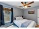 Well lit bedroom with a ceiling fan, a picture, and a window with dark curtains at 34231 Shadewood Cir, Leesburg, FL 34788