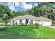 Well-maintained home with a lush green lawn and an inviting entrance surrounded by charming landscaping at 34231 Shadewood Cir, Leesburg, FL 34788
