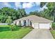 Beautiful home showcasing a pristine lawn, tidy landscaping, and welcoming front entrance at 34231 Shadewood Cir, Leesburg, FL 34788