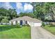 Charming single-story home with a well-manicured lawn, inviting curb appeal, and attached garage at 34231 Shadewood Cir, Leesburg, FL 34788