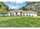 Lush green lawn complements this home's architecture, creating a welcoming and picturesque setting at 34231 Shadewood Cir, Leesburg, FL 34788
