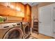 Well-equipped laundry room features modern Samsung washer and dryer, with ample storage cabinets above at 34231 Shadewood Cir, Leesburg, FL 34788