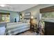 Bright main bedroom features a tray ceiling, guitars, three windows, and hard floors at 34231 Shadewood Cir, Leesburg, FL 34788