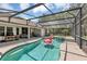 Enjoy outdoor living with a screened pool and covered patio, set against a backdrop of a green lawn at 34231 Shadewood Cir, Leesburg, FL 34788