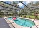 Screened pool and spa area is surrounded by lush landscaping, perfect for outdoor relaxation and entertainment at 34231 Shadewood Cir, Leesburg, FL 34788