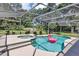 Backyard oasis with a screened-in pool and spa, offering a private retreat surrounded by landscaping at 34231 Shadewood Cir, Leesburg, FL 34788
