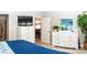 Comfortable bedroom featuring white dressers, a flat-screen TV, and stylish decor at 3466 Smedley Rd, The Villages, FL 32163
