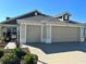 Charming home exterior features a two-car garage, beautiful landscaping, and a welcoming walkway at 3466 Smedley Rd, The Villages, FL 32163
