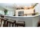 Kitchen with a bar, seating, white cabinets, stainless steel refrigerator, and sleek countertops at 3466 Smedley Rd, The Villages, FL 32163