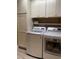The laundry room features modern washer and dryer with ample storage and shelving above at 3466 Smedley Rd, The Villages, FL 32163