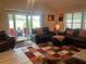 Cozy living room with plush leather furniture, a colorful rug, and sliding doors to the patio at 3466 Smedley Rd, The Villages, FL 32163