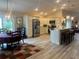 Open-concept living space with dining area, kitchen with stainless steel appliances, and bar seating at 3466 Smedley Rd, The Villages, FL 32163