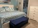 Comfortable bedroom featuring a decorative bed with a padded bench, ensuite bathroom, and a large dresser for storage at 3466 Smedley Rd, The Villages, FL 32163