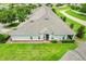 Aerial view of a single-story home with a manicured lawn, trimmed shrubs, and a well-maintained roof at 3547 Fairwaters Ct # F, Clermont, FL 34711