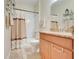 Bathroom with shower-tub combo with curtain, light-colored vanity with granite countertop, and neutral tile flooring at 3547 Fairwaters Ct # F, Clermont, FL 34711