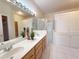 Bright bathroom features a double sink vanity, large mirror, and a glass enclosed shower at 3555 Chapel Hill Blvd, Clermont, FL 34711