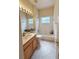Bright bathroom featuring a tub and shower, frosted window, and light wood vanity at 3555 Chapel Hill Blvd, Clermont, FL 34711