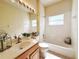 Bright bathroom featuring a tub and shower, frosted window, and light wood vanity at 3555 Chapel Hill Blvd, Clermont, FL 34711