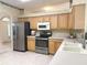 Well-equipped kitchen featuring stainless steel appliances, ample cabinetry, and tile flooring for practical and stylish living at 3555 Chapel Hill Blvd, Clermont, FL 34711