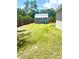 Backyard view showcasing green lawn, shed, and fenced yard, offering plenty of room for entertaining and relaxing at 4002 Sw 158Th Street Rd, Ocala, FL 34473
