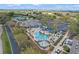 Aerial view of community pool, hot tub, seating, parking and other amenities with palm trees and lush landscaping at 4239 Fawn Meadows Cir, Clermont, FL 34711